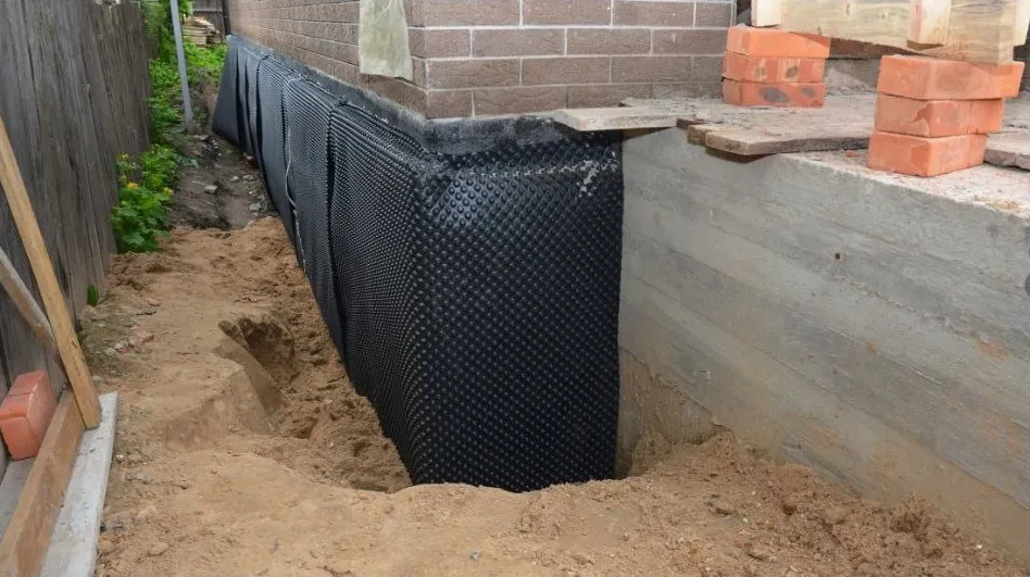 Black dimpled sheet on a dug-out house wall
