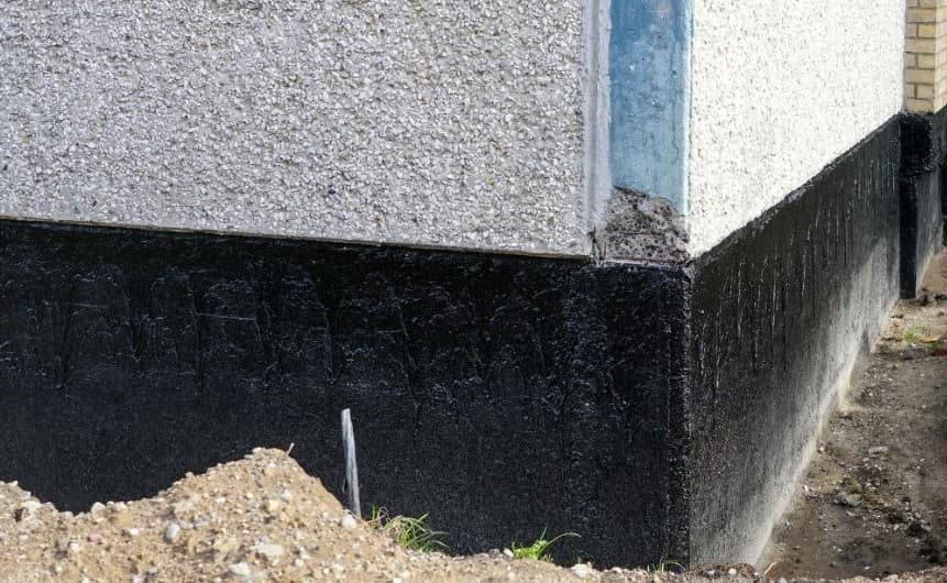 Black coating on a house wall at ground level